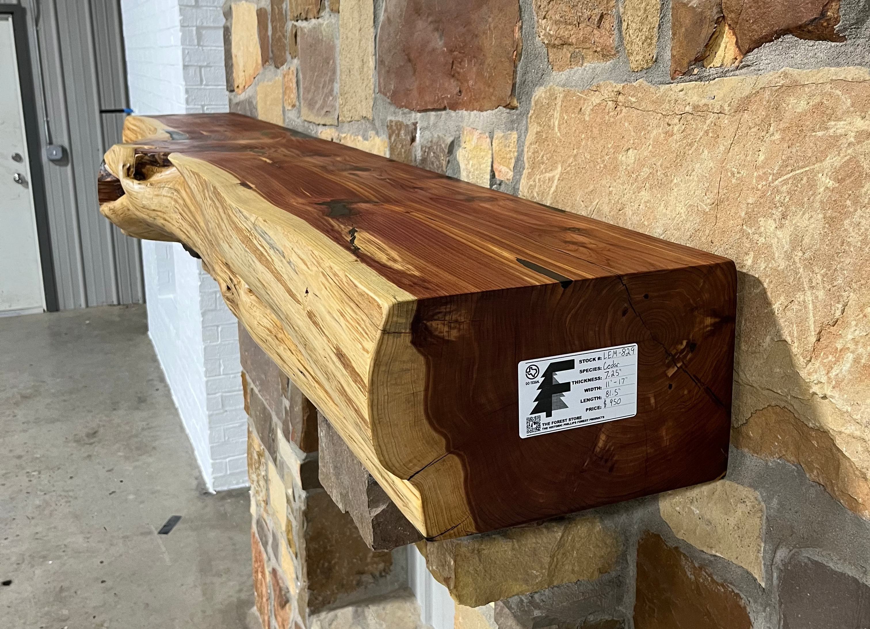 Solid live edge cedar fireplace mantel mounted on a stone wall.
