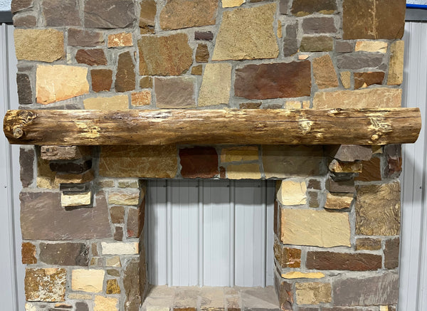 Solid live edge oak fireplace mantel mounted on a stone wall.