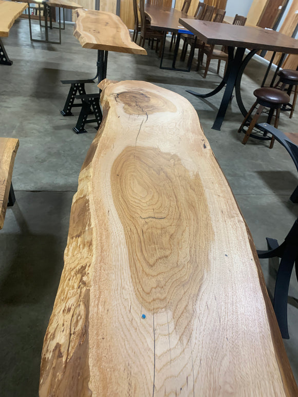 Live edge pecan slab with rich golden-brown tones, natural grain patterns, and organic edges