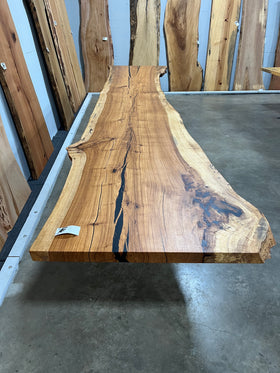 Live edge pecan slab with rich golden-brown tones, natural grain patterns, and organic edges