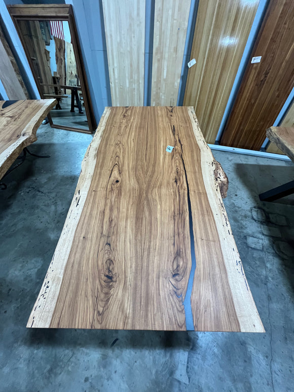 Live edge pecan slab with rich golden-brown tones, natural grain patterns, and organic edges
