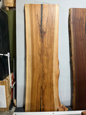 Live edge pecan slab with rich golden-brown tones, natural grain patterns, and organic edges