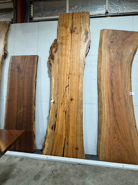 Live edge pecan slab with rich golden-brown tones, natural grain patterns, and organic edges
