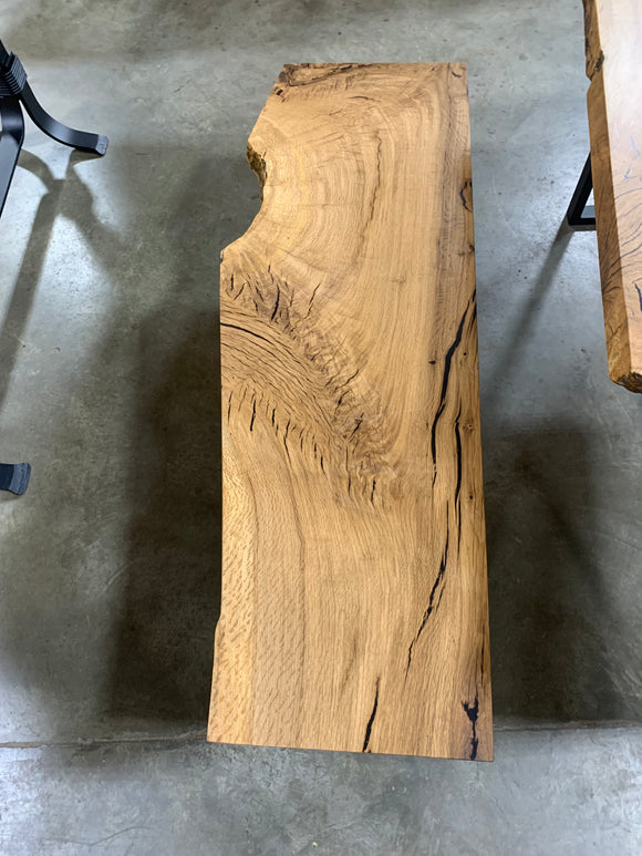 Close-up of a live edge post oak slab with natural grain and knots