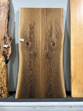 Close-up of a live edge post oak slab with natural grain and knots.