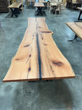 Live edge red oak wood slab with rich grain patterns, natural knots, and kiln-dried hardwood surface for custom furniture or table making.