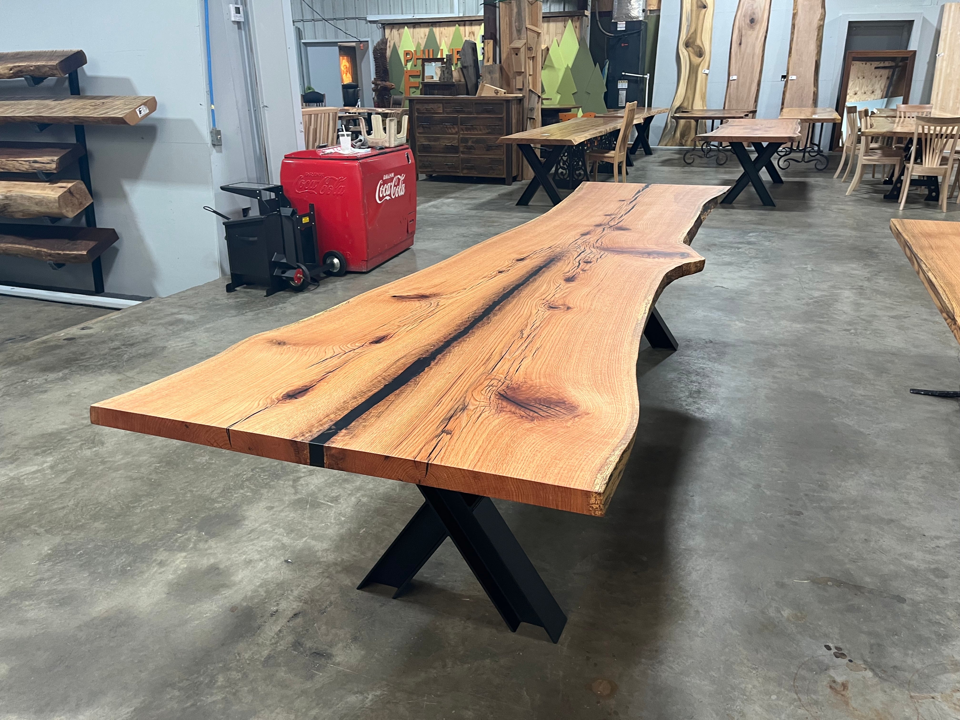 Live edge red oak wood slab with rich grain patterns, natural knots, and kiln-dried hardwood surface for custom furniture or table making.