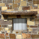 Solid live edge walnut fireplace mantel mounted on a stone wall.