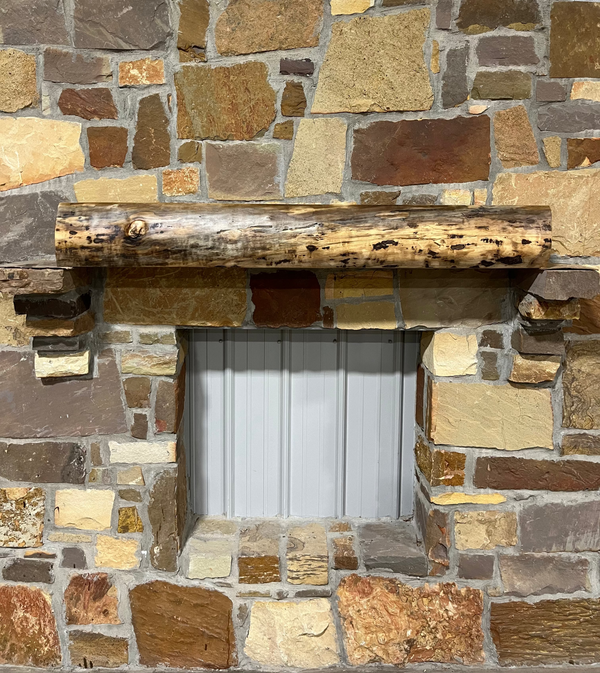 Solid live edge walnut fireplace mantel mounted on a stone wall.