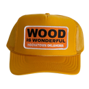A mustard yellow trucker hat with a Wood is Wonderful Hochatown Oklahoma patch