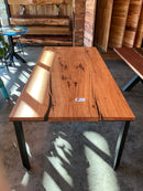 Pecan Spine Table side view with golden-brown wood, black resin cracks, and steel braces.