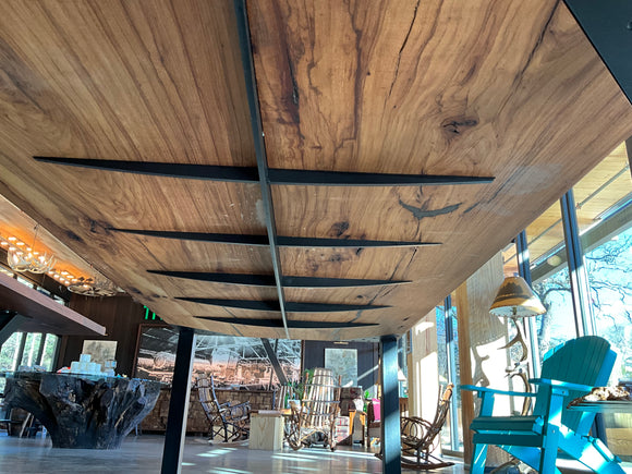 Pecan Spine Table side view with golden-brown wood, black resin cracks, and steel braces.