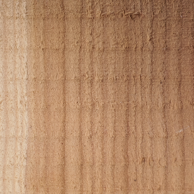 Close-up view of a piece of rough sawn cedar lumber displaying its wood grain
