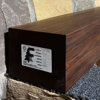 Solid walnut beam fireplace mantel with mounted on a stone fireplace wall.