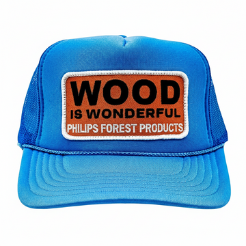 Blue trucker hat with 'Wood is Wonderful' Phillips Forest Products patch on a white background