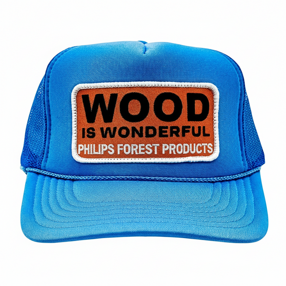 Blue trucker hat with 'Wood is Wonderful' Phillips Forest Products patch on a white background