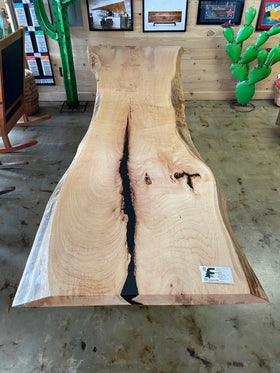 Live edge pecan slab with rich golden-brown tones, natural grain patterns, and organic edges