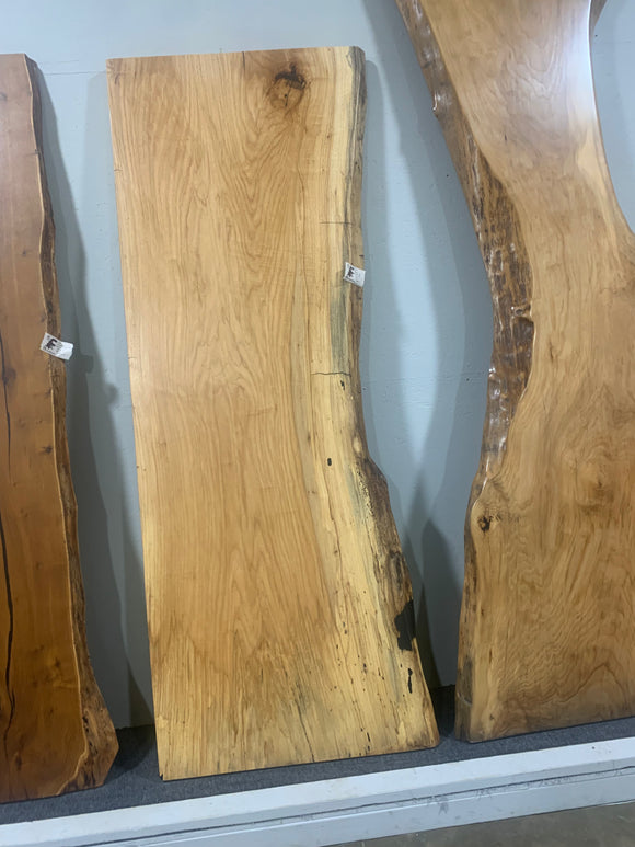 Live edge pecan slab with rich golden-brown tones, natural grain patterns, and organic edges