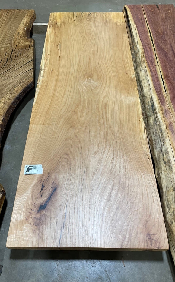 Live edge pecan slab with rich golden-brown tones, natural grain patterns, and organic edges