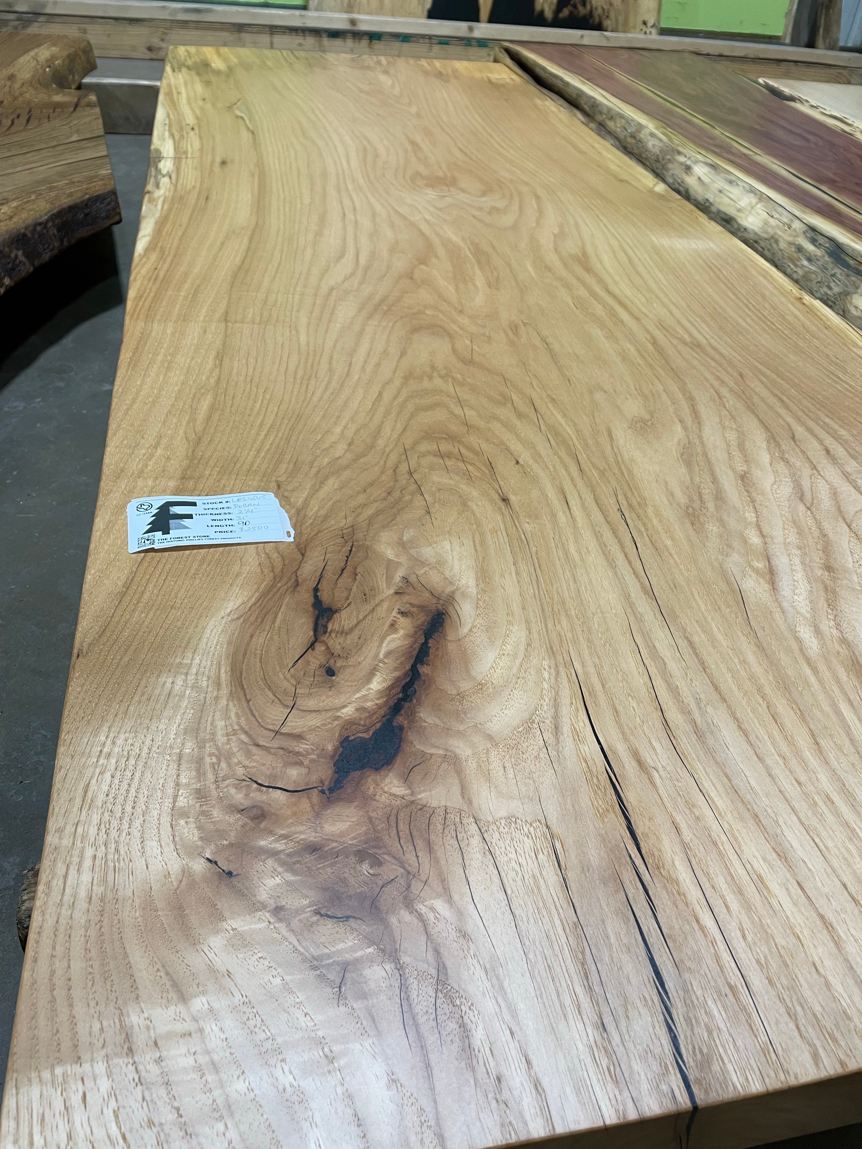 Live edge pecan slab with rich golden-brown tones, natural grain patterns, and organic edges
