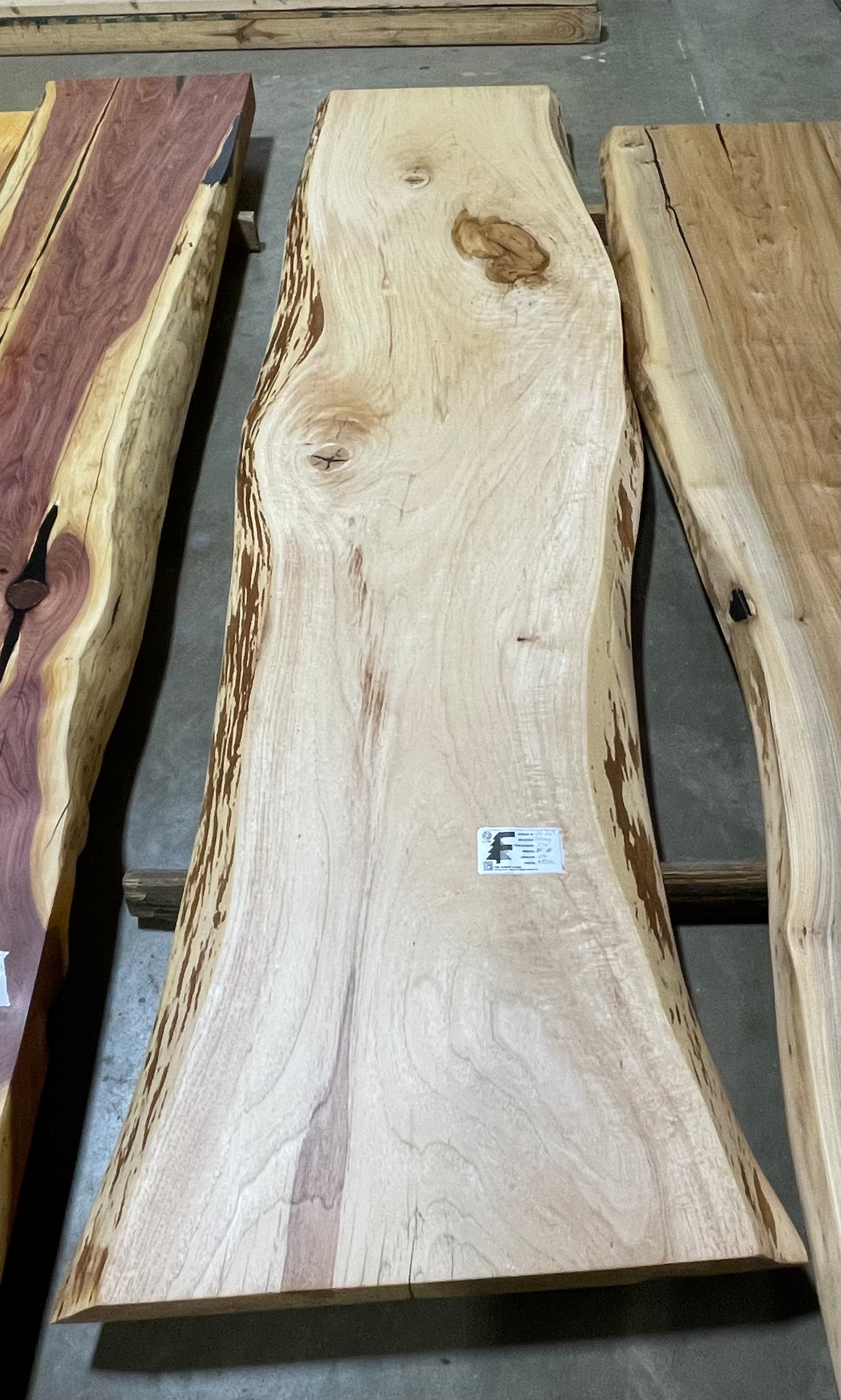 Live edge pecan slab with rich golden-brown tones, natural grain patterns, and organic edges
