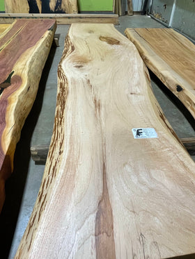 Live edge pecan slab with rich golden-brown tones, natural grain patterns, and organic edges