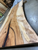 Live edge pecan slab with rich golden-brown tones, natural grain patterns, and organic edges