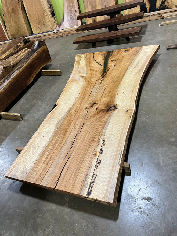 Live edge pecan slab with rich golden-brown tones, natural grain patterns, and organic edges