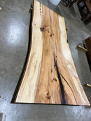 Live edge pecan slab with rich golden-brown tones, natural grain patterns, and organic edges