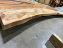 Live edge pecan slab with rich golden-brown tones, natural grain patterns, and organic edges
