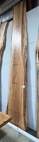 Live edge pecan slab with rich golden-brown tones, natural grain patterns, and organic edges