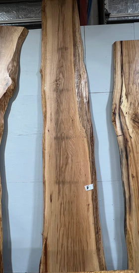 Live edge pecan slab with rich golden-brown tones, natural grain patterns, and organic edges