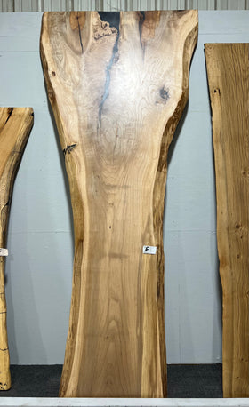 Live edge pecan slab with rich golden-brown tones, natural grain patterns, and organic edges