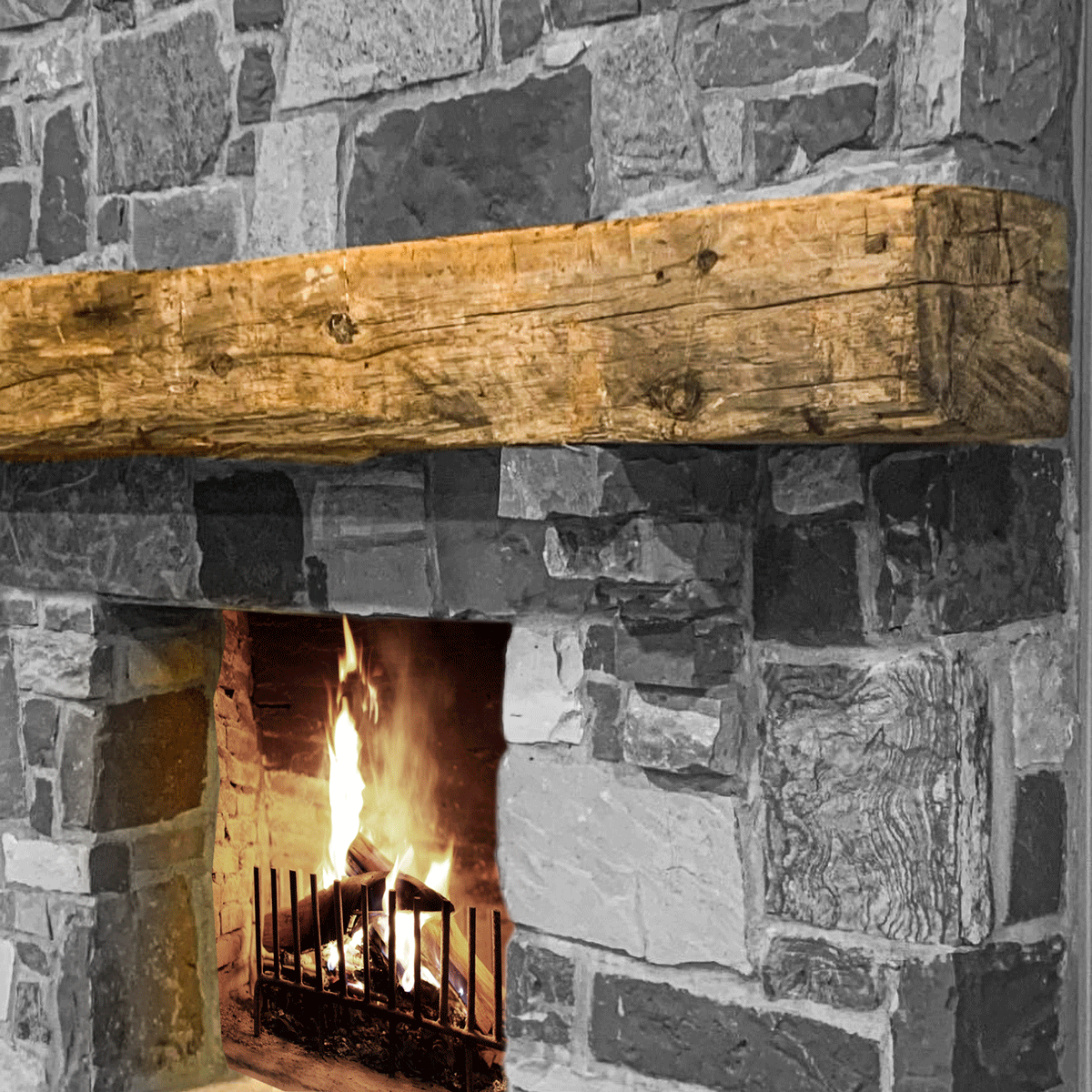 hand hewn reclaimed beam fireplace mantel mounted to stone wall
