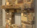 hand hewn reclaimed beam fireplace mantel mounted to stone wall
