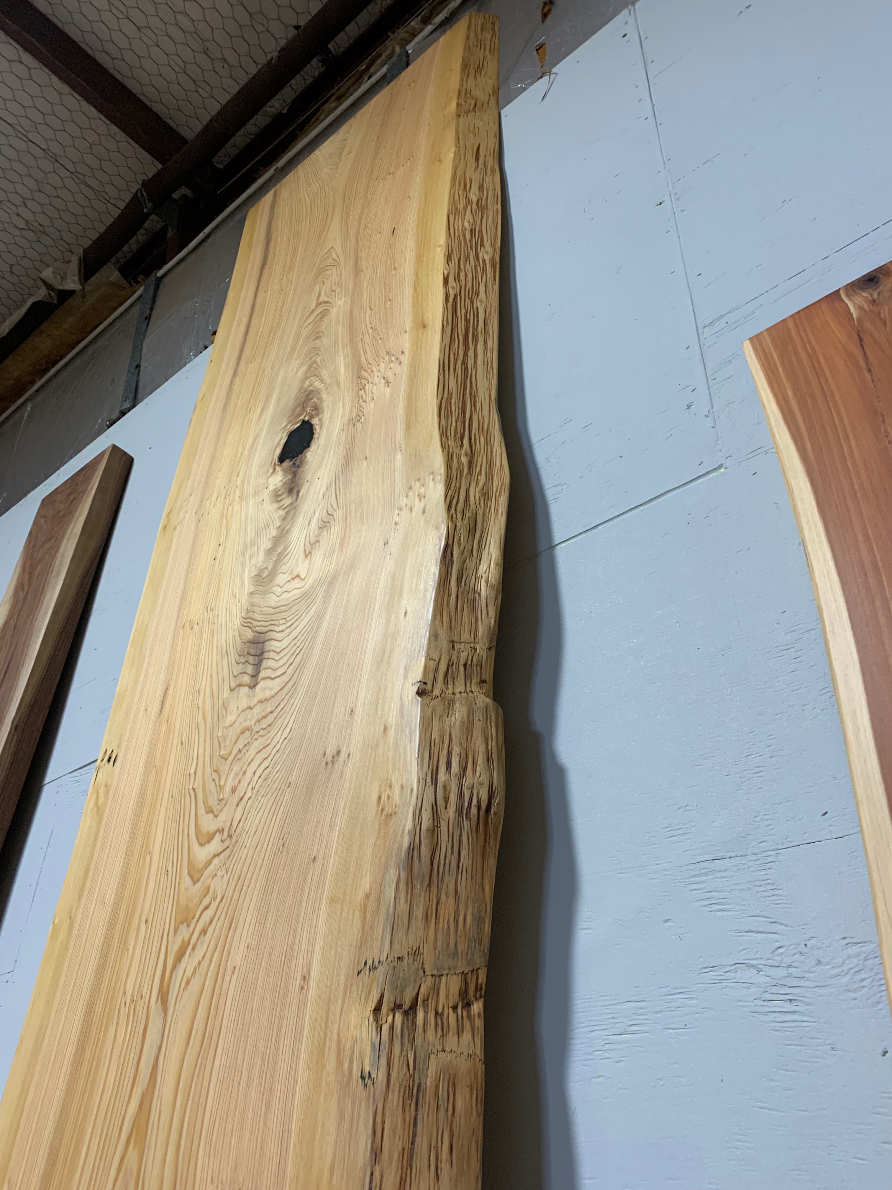 Natural cypress wood slab with rich grain patterns and live edge, perfect for custom dining tables or countertops