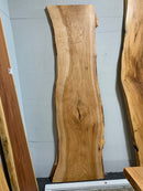 Live edge pecan slab with rich golden-brown tones, natural grain patterns, and organic edges