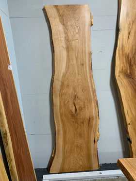 Live edge pecan slab with rich golden-brown tones, natural grain patterns, and organic edges