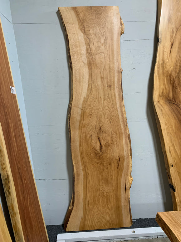 Live edge pecan slab with rich golden-brown tones, natural grain patterns, and organic edges