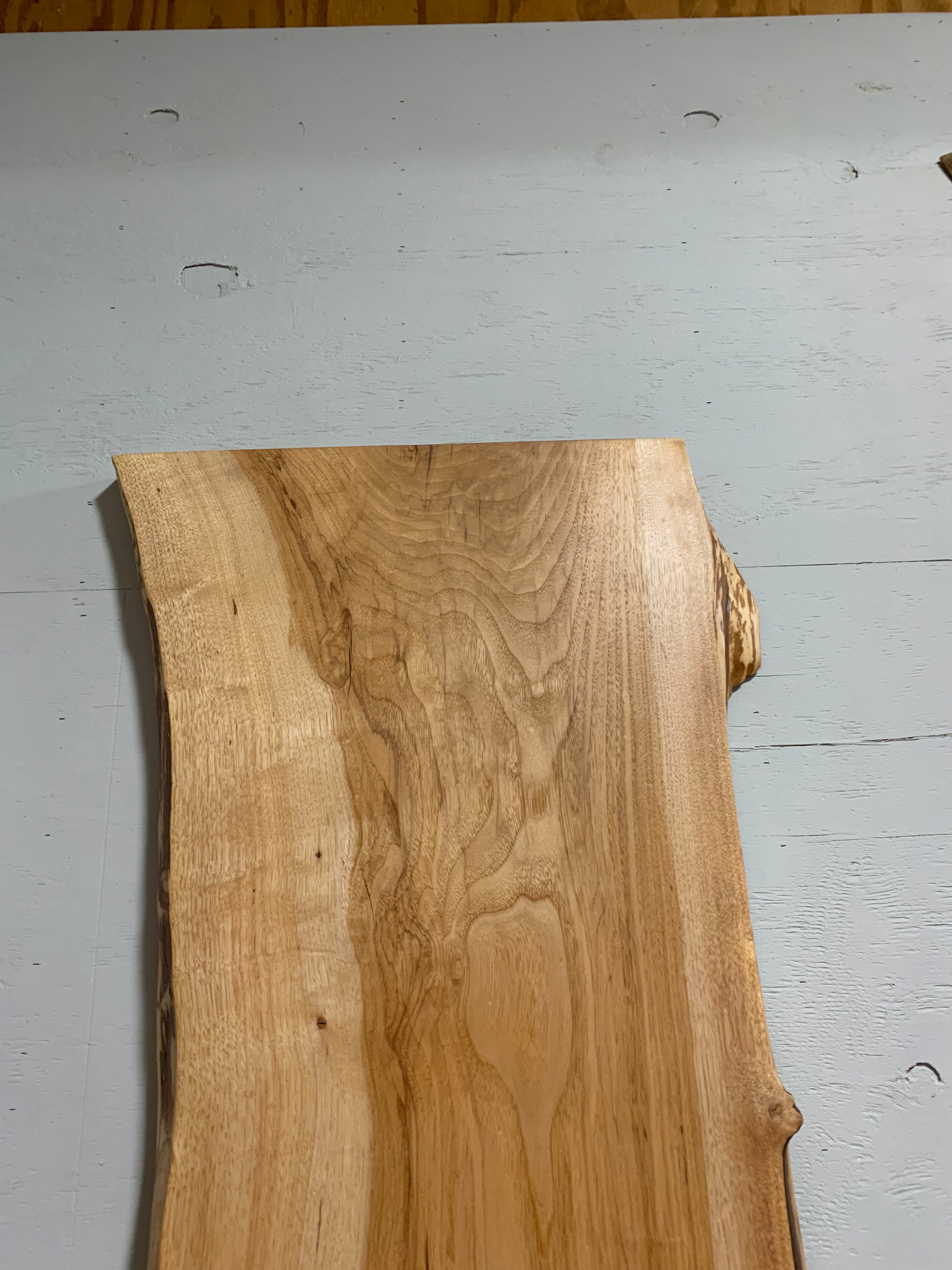 Live edge pecan slab with rich golden-brown tones, natural grain patterns, and organic edges