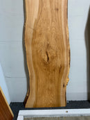 Live edge pecan slab with rich golden-brown tones, natural grain patterns, and organic edges