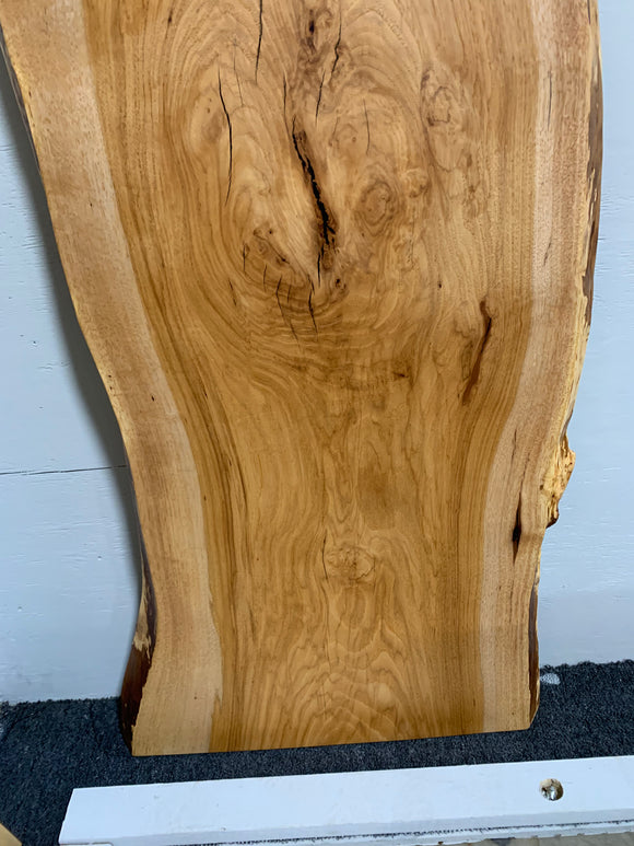Live edge pecan slab with rich golden-brown tones, natural grain patterns, and organic edges