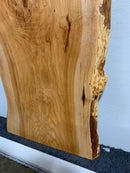 Live edge pecan slab with rich golden-brown tones, natural grain patterns, and organic edges